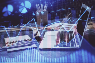 Financial chart drawing and table with computer on background. Double exposure. Concept of international markets.