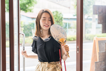 ハンズフリー扇風機を使う若い女性
