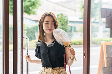 ハンズフリー扇風機を使う若い女性