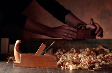 Old wooden jointer and shaving on wooden table.