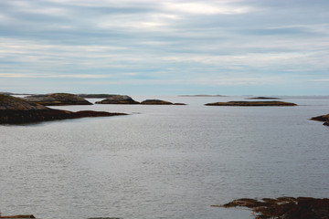 view from the atlantic ocean road with calmy sea with little islands and cloudy sky, coastline view from atlantic road 64 in norway