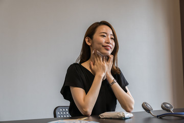 ハンズフリー扇風機を使う若い女性