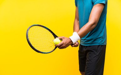 Afro American tennis player man over isolated yellow background