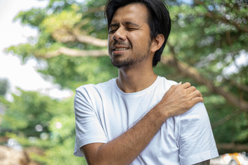 young asian man with pain in shoulder , health care concept