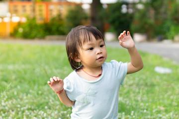 Portrait​ image​ of​ 1-2​ years​ old​ baby.​ Happy​ Asian​ child​ girl​ exercising and​ playing​ at​ the​ playground.​
