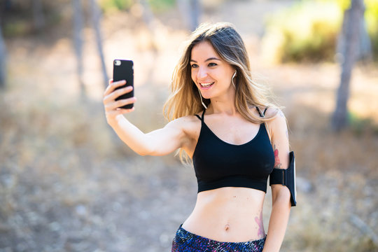 Young sport girl at outdoors making a selfie