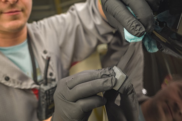 Employee car body painting shop eliminates a small metal defect