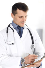 Fototapeta premium Doctor man using clipboard for filling up medication history records. Perfect medical service in clinic. Physician at work in hospital. Medicine and healthcare concepts