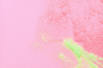 Many multi-colored spangles are scattered on a pink background. View from above. Place for text.