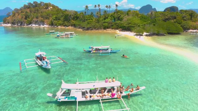 Aerial landsape of Snake Island, fly over tourist boats on the Sandbar and lagoon with turquoise  water. El Nido, Palawan. Philippines.