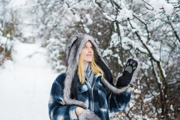 Winter fashion. Happy girl in fur hat and jacket in wintertime. Fur hat. Cold weather. Beautiful stylish woman in winter park. Winter nature background. Christmas and new year. Winter girl outdoor.