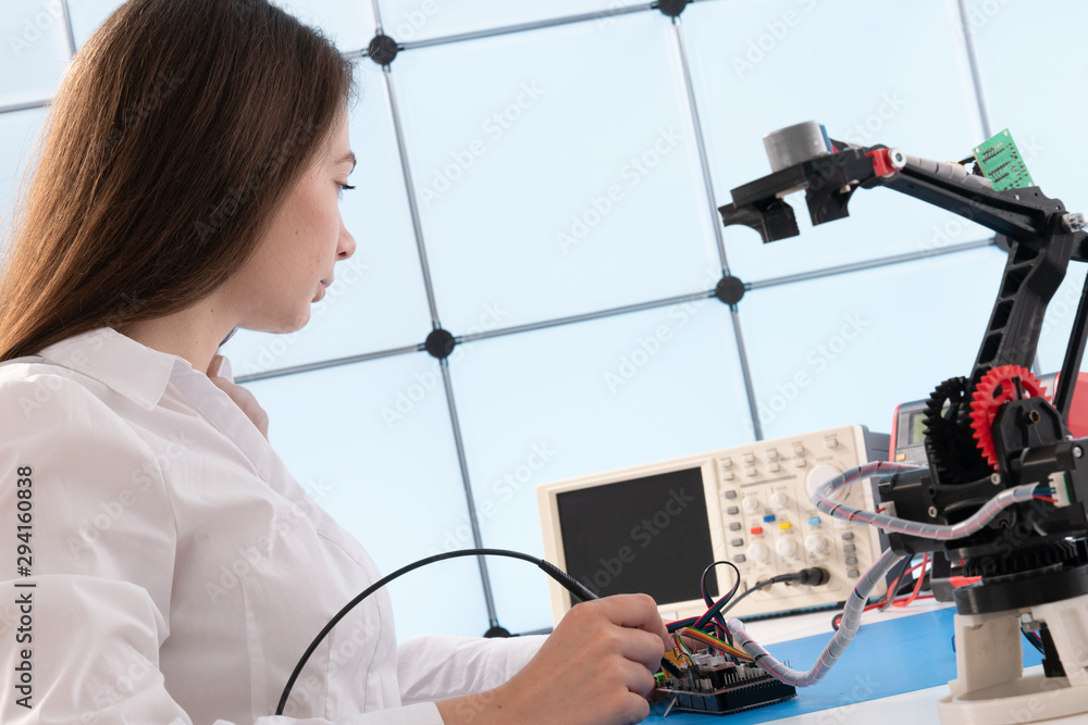 Poster A young woman writes an algorithm for the robot arm. Science Research Laboratory for Robotic Arm Model. Computer Laboratory