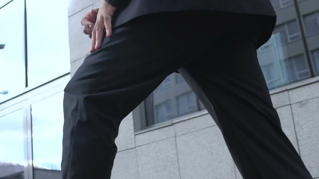 Businessman suffering sharp knee pain outdoors, joint arthritis, health problem