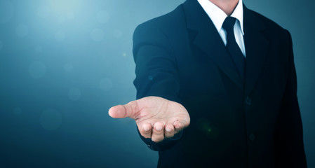 Asian Man standing and shows outstretched hand with open palm on Light of Len flare and Boke blue...