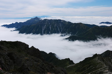 Fototapeta na wymiar 北アルプス　槍ヶ岳山頂からの風景　雲海に浮かぶ笠ヶ岳と白山遠景
