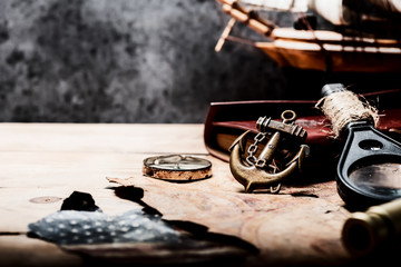 Columbus Day. Pirates and treasure with worldmap and discovery equipment. Copy space on dark...