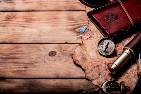 Columbus Day. Pirates and treasure with worldmap and discovery equipment. Copy space on dark background.
