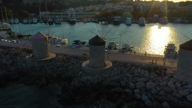 Aerial birds eye view drone video of Rhodes city island, Dodecanese, Greece. Panorama with Mandraki port, lagoon and clear blue water. Famous tourist destination in South Europe