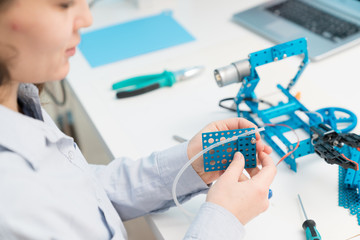 Student woman in robotics laboratory working  on project mechatronics