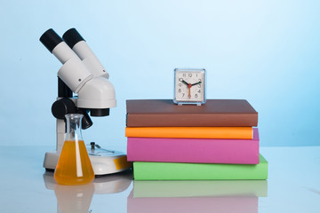 Books and a microscope on the desk of the student
