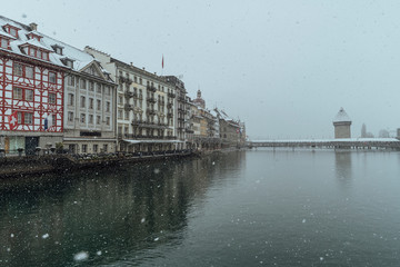 The old town of Lucerne with the roofs of the buildings covered with snow, after a snowfall on a cold winter day.