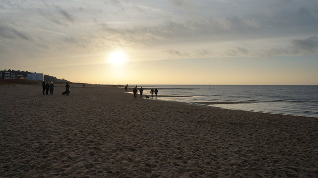 Strand mit Abend&auml;mmerung und ein paar Menschen am Wasser