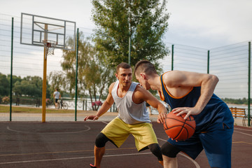 Basketball players playing intense match outdoor
