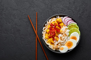 Nan Gyi Thoke in black bowl at dark slate background. Nan gyi Thohk is popular burmese cuisine dish...