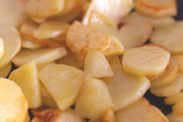Potatoes fried in a pan on vegetable oil. Potato close-up, cooking.