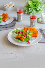 Fresh salad with roasted pumpkin, pomegranates seeds and corn lettuce leaves and pomegranate juice perfect for Autumn.Vegan eating and healthy lifestyle.