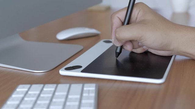 Designer working  on graphic digital tablet , Hand of a man  drawing by electronic pen , Slow motion and Slider view.