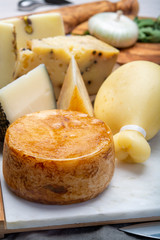 Variety of Italian pecorino and provolone cheeses, yellow aged, with black peppers from Nebrodi, white Il Palio and black molarotto, close up