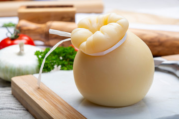 Italian provolone or provola caciocavallo hard cheese in teardrop form served on white marble plate...