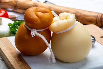 Italian provolone or provola caciocavallo hard and smoked cheeses in teardrop form served on white...