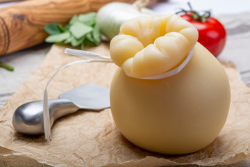 Italian provolone or provola caciocavallo hard cheese in teardrop form served on old paper close up