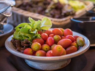 Cherry tomato and red oak lettuce in a same bowl