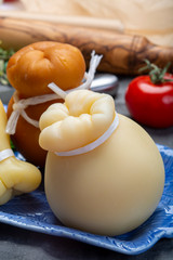 Italian provolone caciocavallo aged and smoked cheeses in teardrop form served on blue plate close...