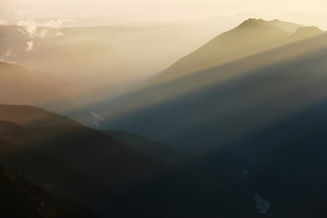 北アルプス　槍穂高大キレット縦走　南岳山頂からの風景　夕陽の光芒と笠ヶ岳のシルエット