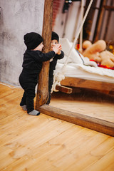 Vertical portrait of baby boy and big mirror. Beautiful little man celebrates New Year