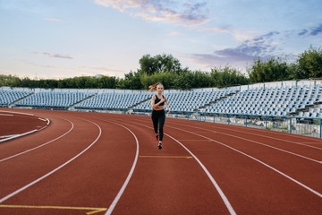 Female jogger running, training on stadium