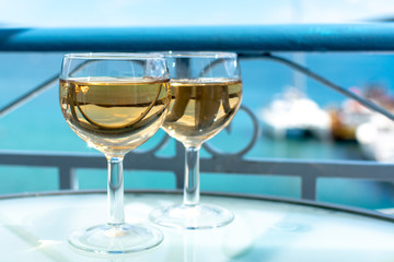 White wine served outside on balcony on glass table with sea view