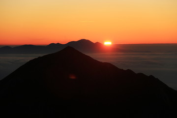 北アルプス　南岳山頂からの風景　常念岳越しの浅間山からの日の出