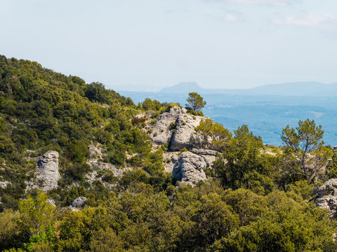 Paysage de Provence. Mont&eacute;e vers le Gros Bessillon par la route de la cr&ecirc;te bord&eacute;e par de gros rochers dont la Roche Trou&eacute;e et la Gorge de Cinq heures