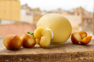 Italian provolone caciocavallo aged and smoked cheeses in teardrop form with yellow houises of old...