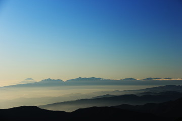	北アルプス　南岳山頂からの風景　朝靄の富士山、南アルプス遠景