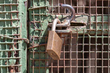 A close up view of a padlock keeping a metal gate closed