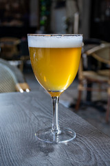 Famous Belgian beer served outside in small old cafe in special Belgian beer glass
