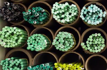Colored glass sticks in a glassblowing workshop. Background.