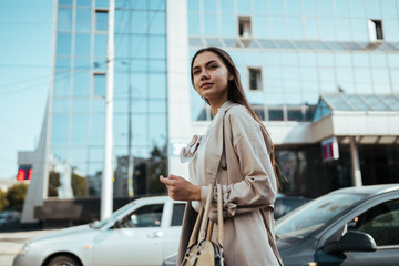 Young busy business woman with long dark hair in a white blouse walks around the city for a meeting