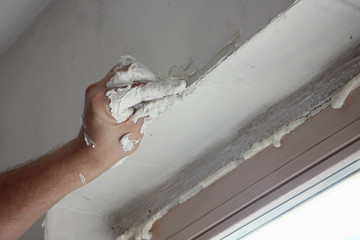 Hand worker carelessly apply putty on the window opening